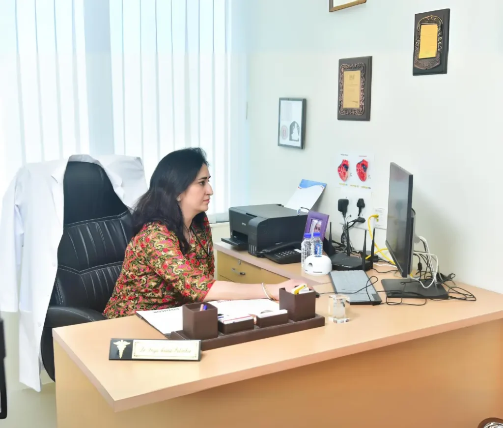 cardiologist Priya Palimkar sitting at her desk